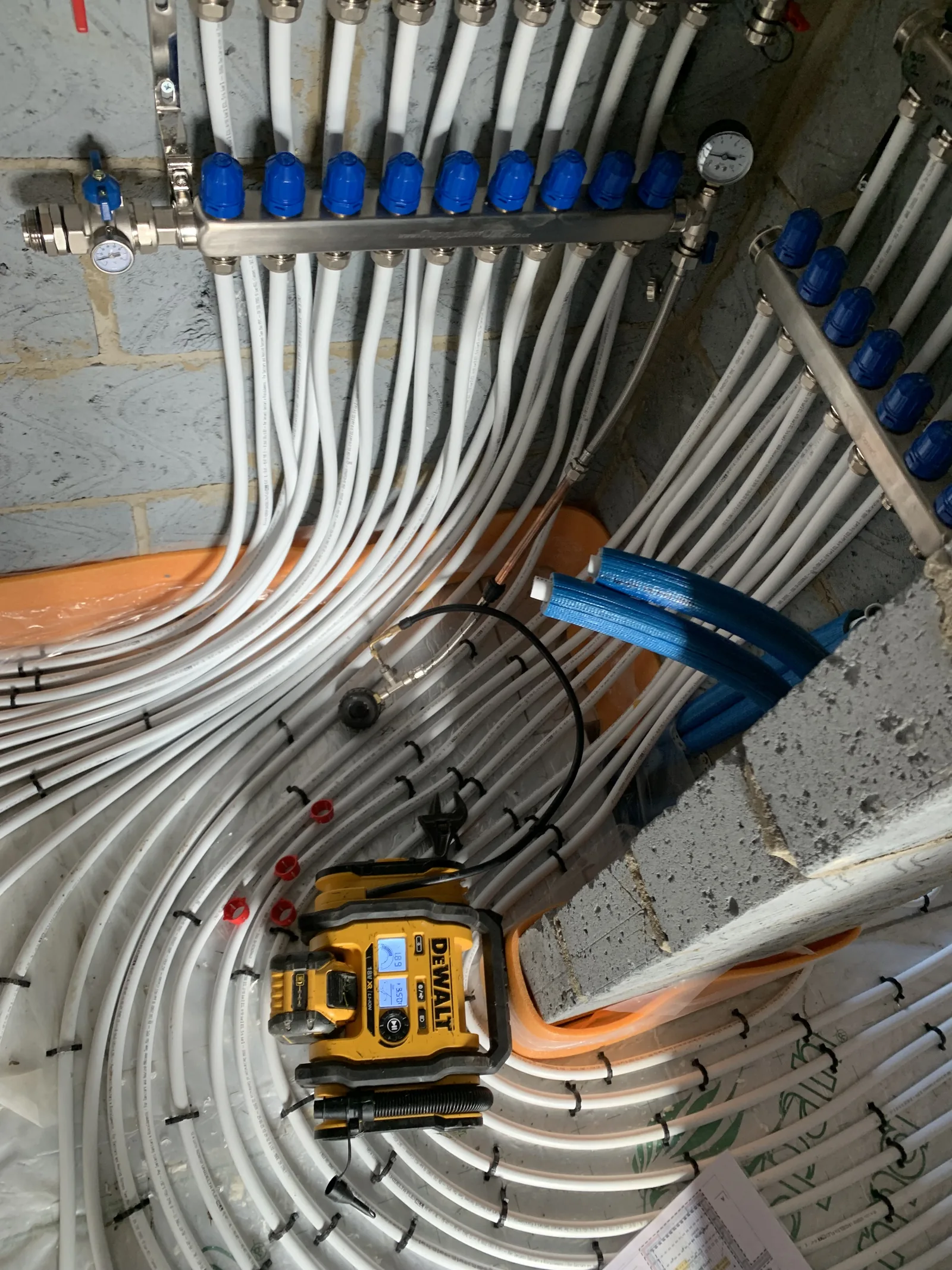 Underfloor heating manifold with blue actuators in Great Moulton installation