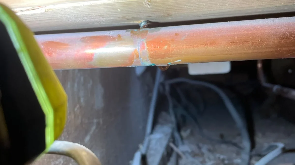 Central heating pipe leak repair in Norwich showing punctured copper pipe