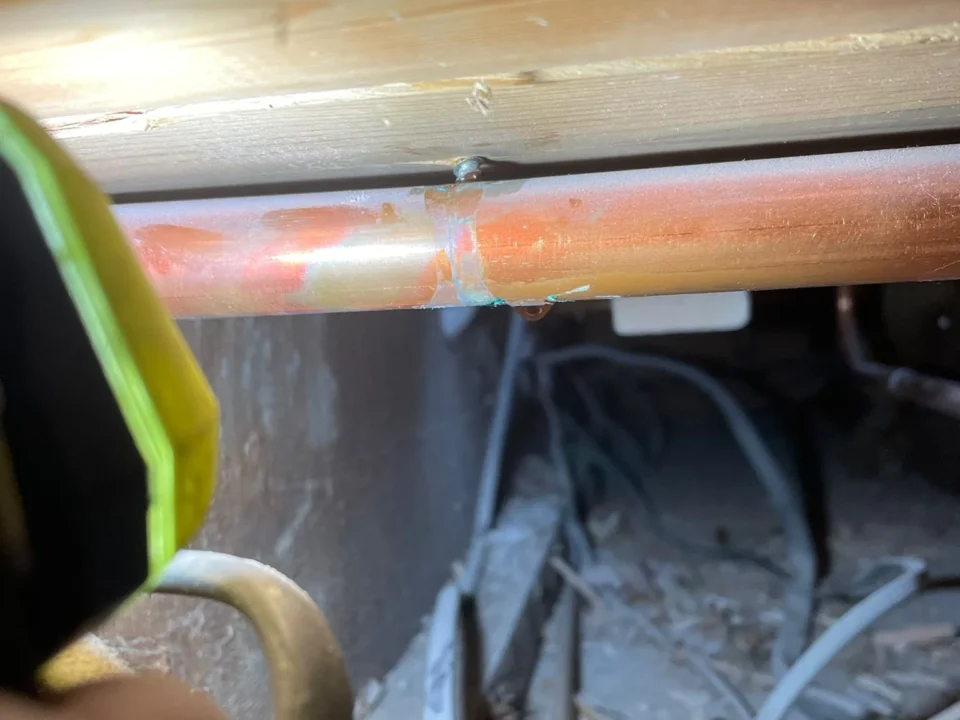 Central heating pipe leak repair in Norwich showing punctured copper pipe