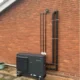Panasonic Aquarea 7kW monobloc air source heat pump installed outside brick wall in Shropham Norfolk