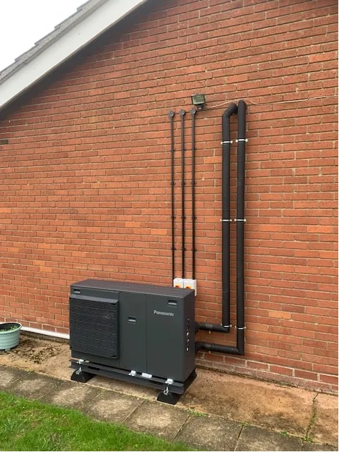 Panasonic Aquarea 7kW monobloc air source heat pump installed outside brick wall in Shropham Norfolk